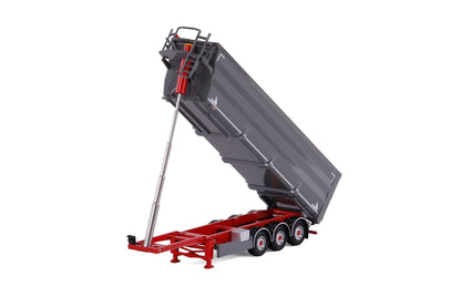 A miniature toy dump truck trailer, likely a scale model, featuring a gray tipping dump body and a red chassis with a silver support arm, shown on a white background.